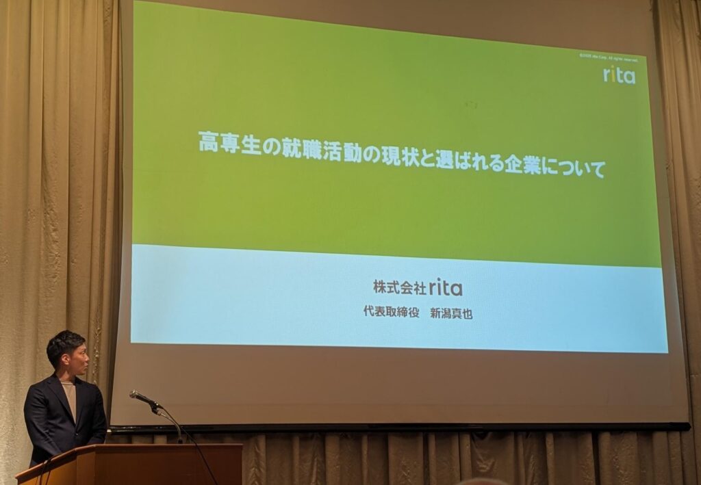 株式会社ritaの代表取締役:新潟真也が、さいたま市リーディングエッジ企業の経営陣約30名に向けて「高専生の就職活動の現状と選ばれる企業について」の講演をした時の画像。代表の新潟本人と、公演スライドのタイトルが映っている。