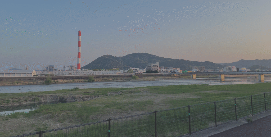 宮崎県延岡市の風景が映っている。旭化成の工場のシンボルである煙突が映っている